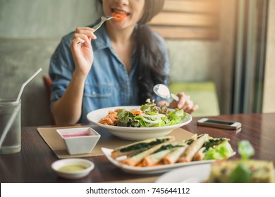 Closeup of a woman eating healthy salad . Beautiful smiling woman eating healthy salad.