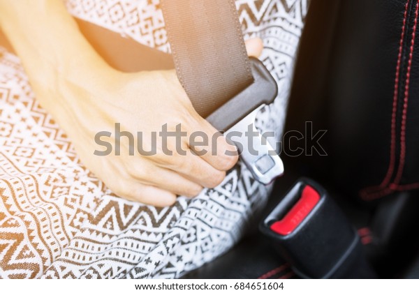 Closeup of woman fastening seat belt in car For\
safety before driving on the\
road.