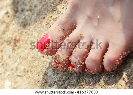 Closeup of woman feet on beach sand.