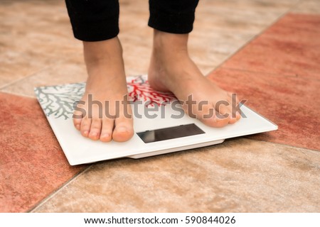 close-up of woman feet on digital scale in bathroom