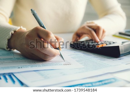  Closeup woman filling form of Individual Income Tax Return,