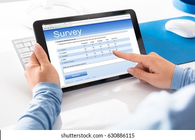 Close-up Of A Woman Filling Online Survey Form On Digital Tablet