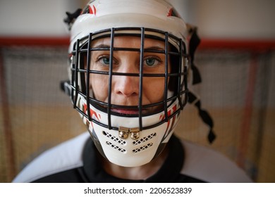 Close-up of woman floorball goalkeeper in helmet concetrating on game in gym. - Powered by Shutterstock