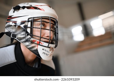 Close-up of woman floorball goalkeeper in helmet concetrating on game in gym. - Powered by Shutterstock