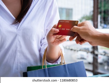 Close-up of woman giving a credit card to shopping.
