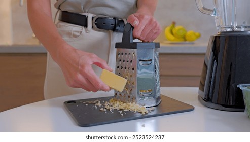 Close-up of Woman Grating Cheese in a Modern Kitchen, Dubai, UAE. High quality photo - Powered by Shutterstock