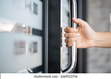 Closeup Woman Hand Holding The Door Bar To Open The Door With Glass Reflection Background.