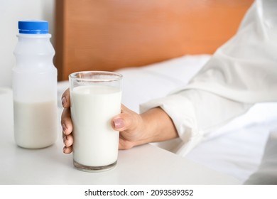 closeup woman hand holding a glass of milk, drinking milk before sleeping 