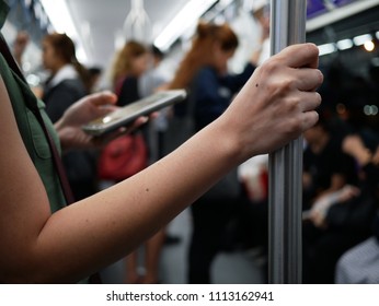 closeup woman hand holding handrail inside the train.