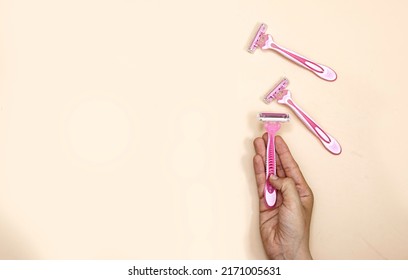 Closeup Woman Hand Holding Pink Disposable Razors. Depilation And Skin Care Concept