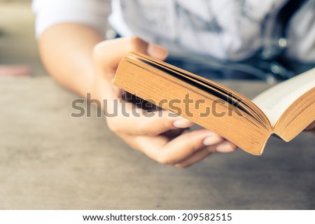 Closeup woman hand  holding pocket book to read