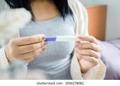 Closeup Woman Hand Holding Pregnancy Test Looking At The Positive, Negative Result, New Life Concept 