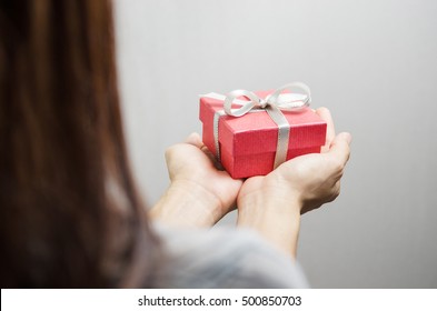 Nahaufnahme, Frauenhand mit rotem Geschenkbox, Geschenk für Frauen, Neujahrsferien und Grußsaison-Konzept, Rückblick.