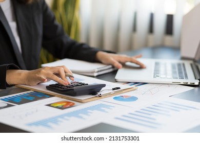 Close-up Woman Hand Press Calculator To Calculate The Company's Financial Results On The Wooden Table In The Office And Business Work Background, Tax, Accounting, Statistics, And Analytical Research.