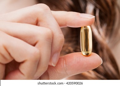 Closeup Of Woman Hand Showing Omega-3 Capsule For Healthy Hair, Strong Nails And Shiny Skin