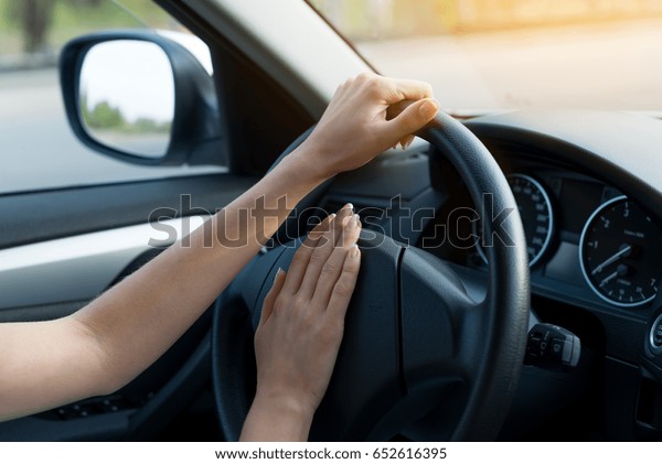 closeup of woman hands behind the wheel. \
concept of lifestyle. stress of driving every day. who gets rights\
today? problems\
drivers.