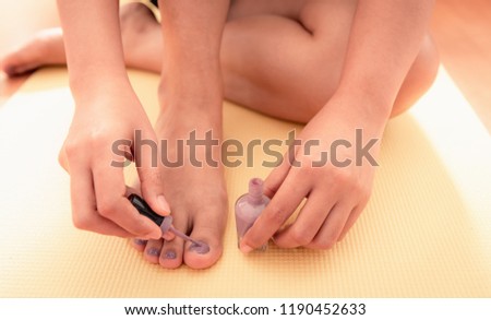 Close-up woman hands being painted her nails feet.