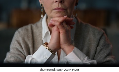 Closeup Woman Hands Crossed In Front Of Computer In Living Room. Thoughtful Senior Business Woman Keeping Chin With Crossed Palms At Home. Old Aged Woman Thinking Near Laptop Computer At Home