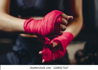 Closeup Of Woman Hands Fist In Sport Protective Bandages On Black Background, Preparing For Tough Fight