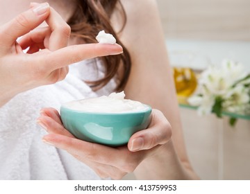 Closeup of woman hands holding a bowl with nourishing mask for applying to hair or skin; beauty and spa concept