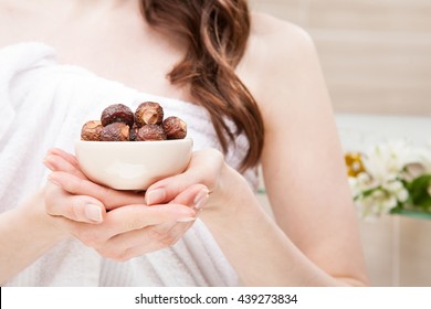 Closeup Of Woman Hands Holding Ceramic Bowl With Soapnuts For Organic Haircare