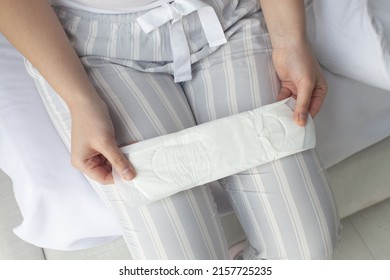 Closeup of woman hands holding sanitary napkins or menstruation pad before wearing it. Women using it during menstruation to avoid damage to clothing.