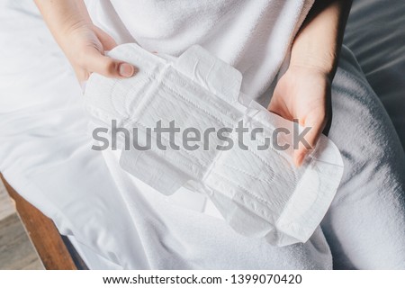 Close-up of woman hands holding sanitary napkins or menstruation pad before wearing it. Women using it during menstruation to avoid damage to clothing