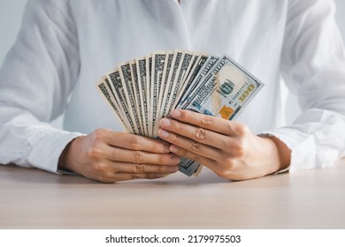 Closeup Woman Hands Holding US Paper Currency On Wood Table, Investment Concept