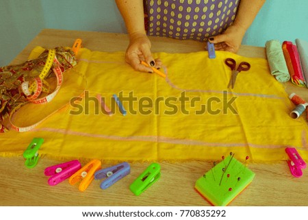 closeup of woman hands sewing yellow cloth outdoors. Woman's Hand Sewing Quilt
