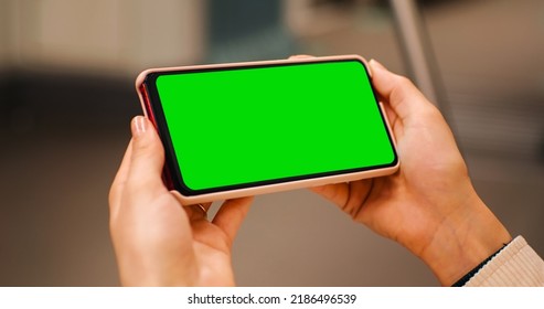 Close-up Woman Hands Watching On The Horizontal Green Screen Phone On Train, Transport. Green Screen Cromakey Phone Used By Woman On Subway. Technology Lifestyle.