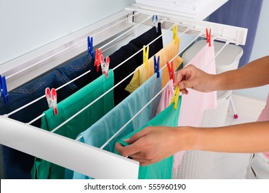 Close-up Of Woman Hanging Wet Clean Cloth On Clothes Line In Laundry Room