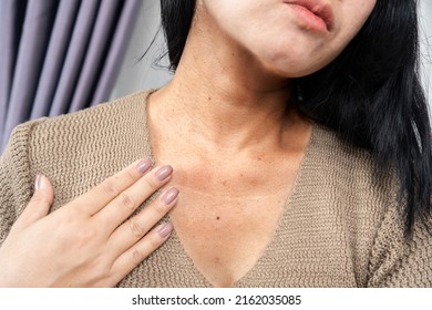 closeup woman having a problem with neck wrinkles, dark skin, aging process concept   - Shutterstock ID 2162035085