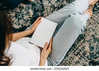 Closeup Of A Woman Holding A Book With White Blank Cover.