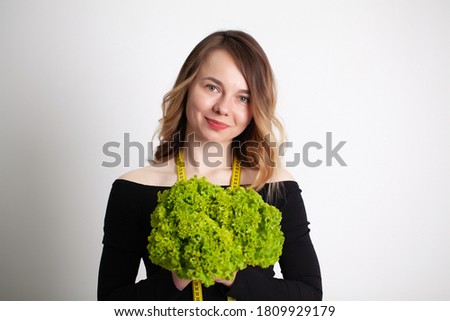 Closeup of woman holding broccoli with string tape to measure