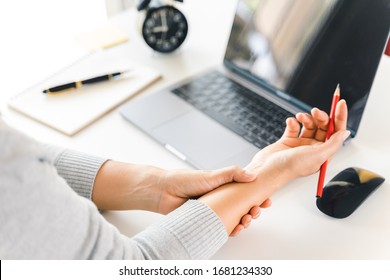 Closeup Woman Holding Her Wrist Pain From Using Computer Long Time. Office Syndrome Concept.