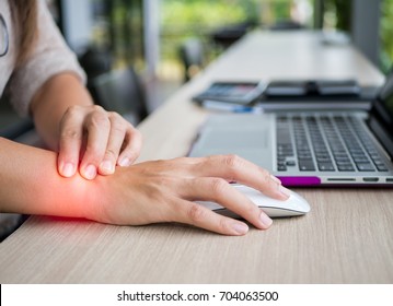Closeup woman holding her wrist pain from using computer. Office syndrome hand pain by occupational disease.