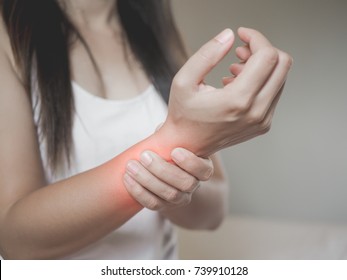 Closeup Woman Holds Her Wrist Hand  Injury, Feeling Pain. Health Care And Medical Conept.