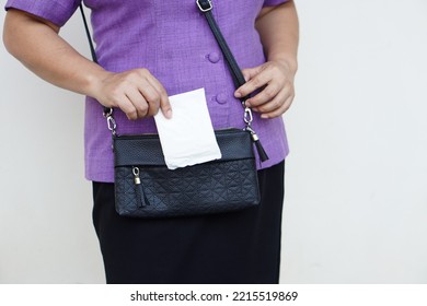 Closeup Woman Holds Sanitary Pad For Menstruation To Put Into Bag Before Going Out. Concept: Female's Hygienic Product For Period's Day. Woman Healthcare. Monthly Intimate Hygiene.                    