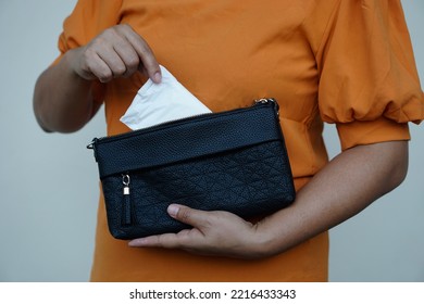 Closeup Woman Holds Sanitary Pad For Menstruation To Put Into Bag Before Going Out. Concept: Female's Hygienic Product For Period's Day. Woman Healthcare. Monthly Intimate Hygiene.                    