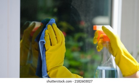 Close-up of woman housemaid using detergent and rag for cleans window. House cleaning, housekeeping and spring-cleaning concept - Shutterstock ID 2182603027