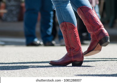 closeup of woman legs with red american boots at country show in outdoor 