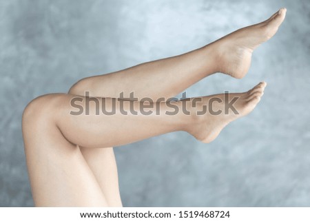 Closeup woman legs relaxing with grey background, beauty and skin care concept, selective focus