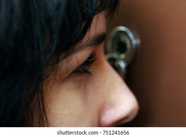 Closeup of woman looking through peephole