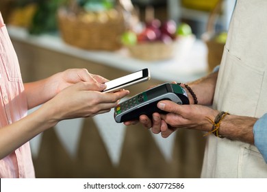 Close-up of woman making a payment by using NFC technology - Shutterstock ID 630772586