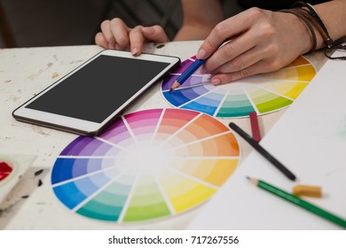 Close-up of woman matching color with color swatch at table - Powered by Shutterstock