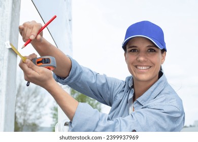 close-up woman measuring of metal plank - Powered by Shutterstock