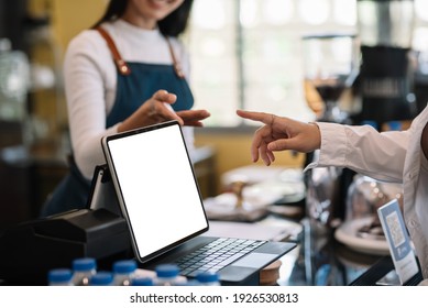 Close-up of a woman ordering coffee on a tablet with a blank white screen at a coffee shop. - Powered by Shutterstock