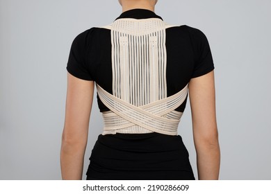 Closeup Of Woman With Orthopedic Corset On Grey Background, Back View