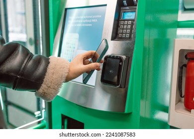 Close  up woman paying at self  service machine using contactless phone payment  Woman take train ticket after buy from subway ticket machine  Transportation concept