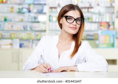 Closeup of a woman pharmacist writing a prescription
